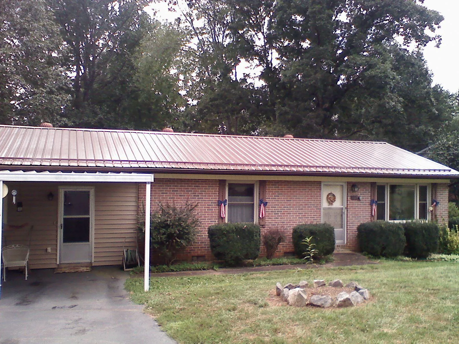 Bronze metal roof and carport on a brick ranch home — Roof Repair work by our crew in Veneta